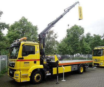 A yellow truck with a loading crane