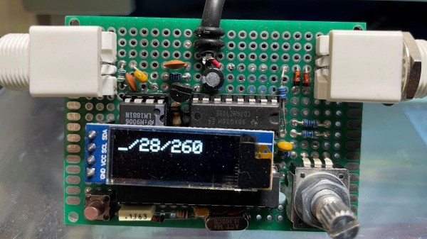 A small green circuit board with a tiny OLED display