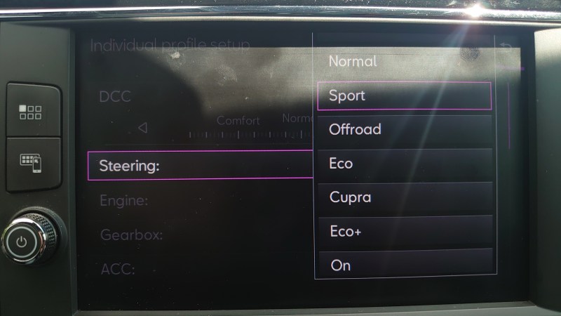 Showing a car dash screen with options menu, showing a "Steering" entry and a bunch of options one can change, i.e. Normal, Sport, offroad, Eco etc.