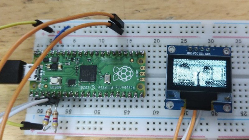 A Pi Pico plugged into a breadboard, with an I2C OLED display connected to it