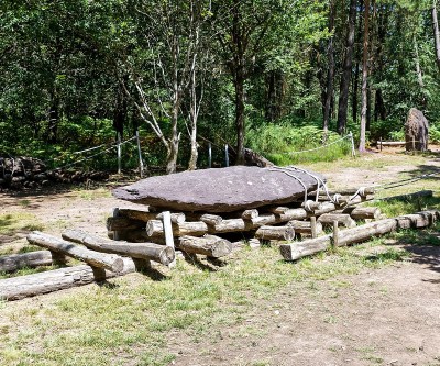 A menhir - a large flat rock - on a set of wooden rollers