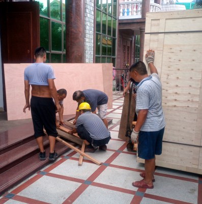 A group of "uncles", Shenzhen handymen, prepare a wooden ramp to move a large machine.
