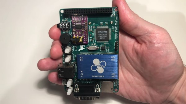 A smartphone-sized PCB is in a person's hand. A large blue chip package houses a 486 and the board has a SoundBlaster card and a 40 PIN Raspberry Pi Connector along one edge for attaching a Raspberry Pi Zero.