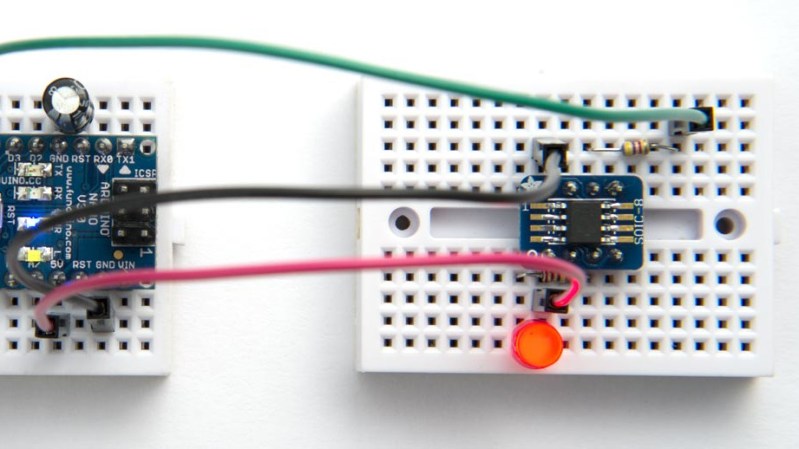 Showing a new generation ATTiny on an SMD breakout plugged into a breadboard, being programmed