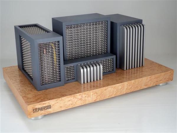 An art deco style computer made of several grey/blue boxes with silver grates on top of a maple platform.
