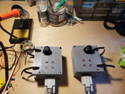 Two 3D-printed boxes with buttons and joysticks, to be attached to a bike's handlebar