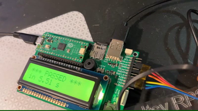 Showing a board with a Pi Pico plugged into it, a USB-A socket marked "USB host", and a character display that says "PASSED" referring to the board being the brains of a testing jig.