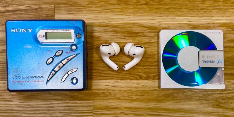 A MiniDisc Walkman, a MiniDisc and a pair of BlueTooth earphones