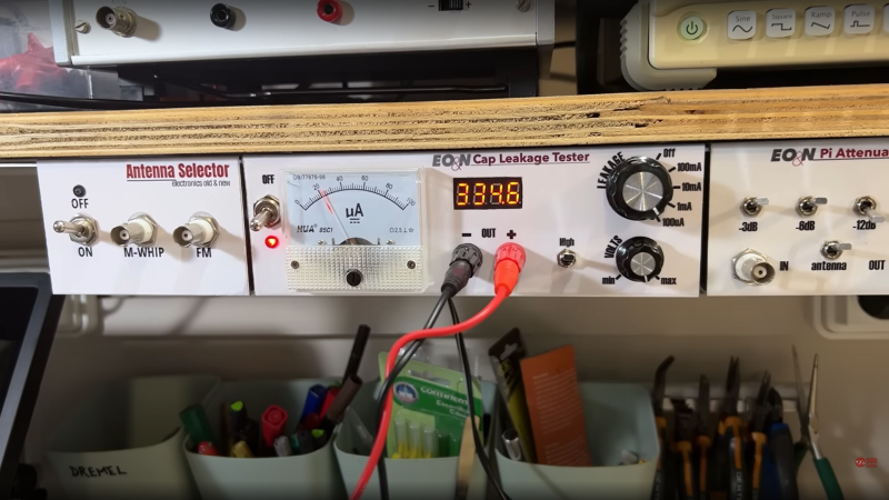 DIY capacitor leakage tester nestled among neighbours all mounted underneath a shelf
