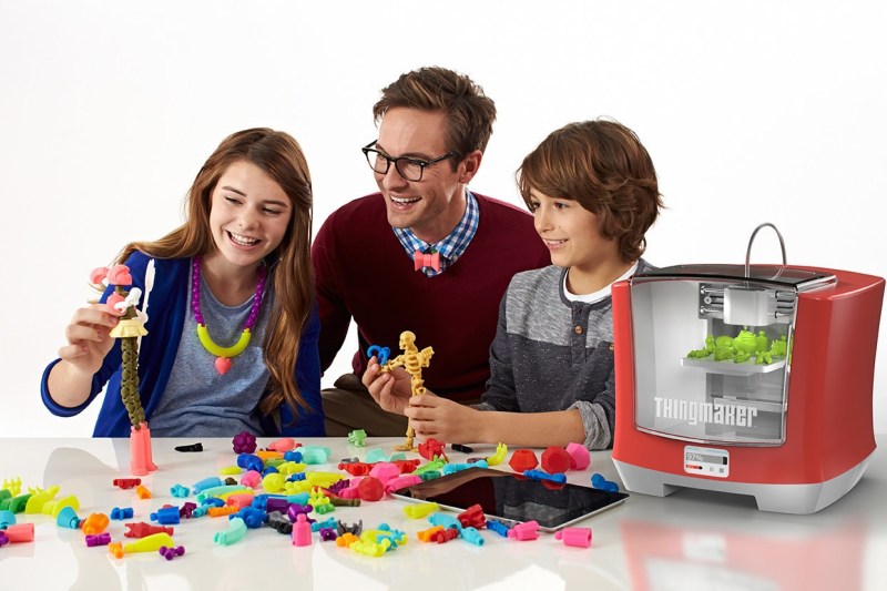Smiling ad family with 3D printer