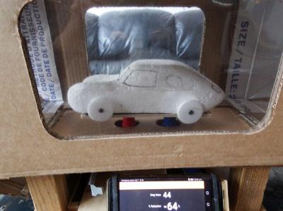 A styrofoam car model in a cardboard wind tunnel