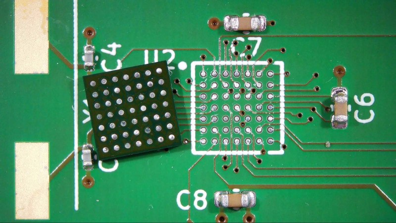 A desoldered and cleaned BGA chip next to its cleaned PCB footprint