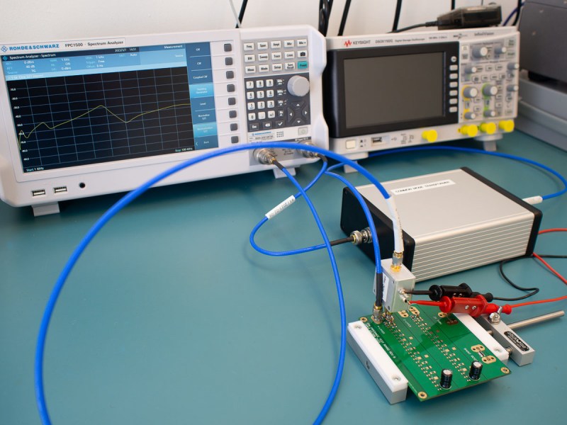 A bench setup with a spectrum analyzer and a PCB under test