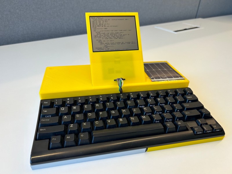 A yellow computer with a black keyboard and a small monochrome LCD screen