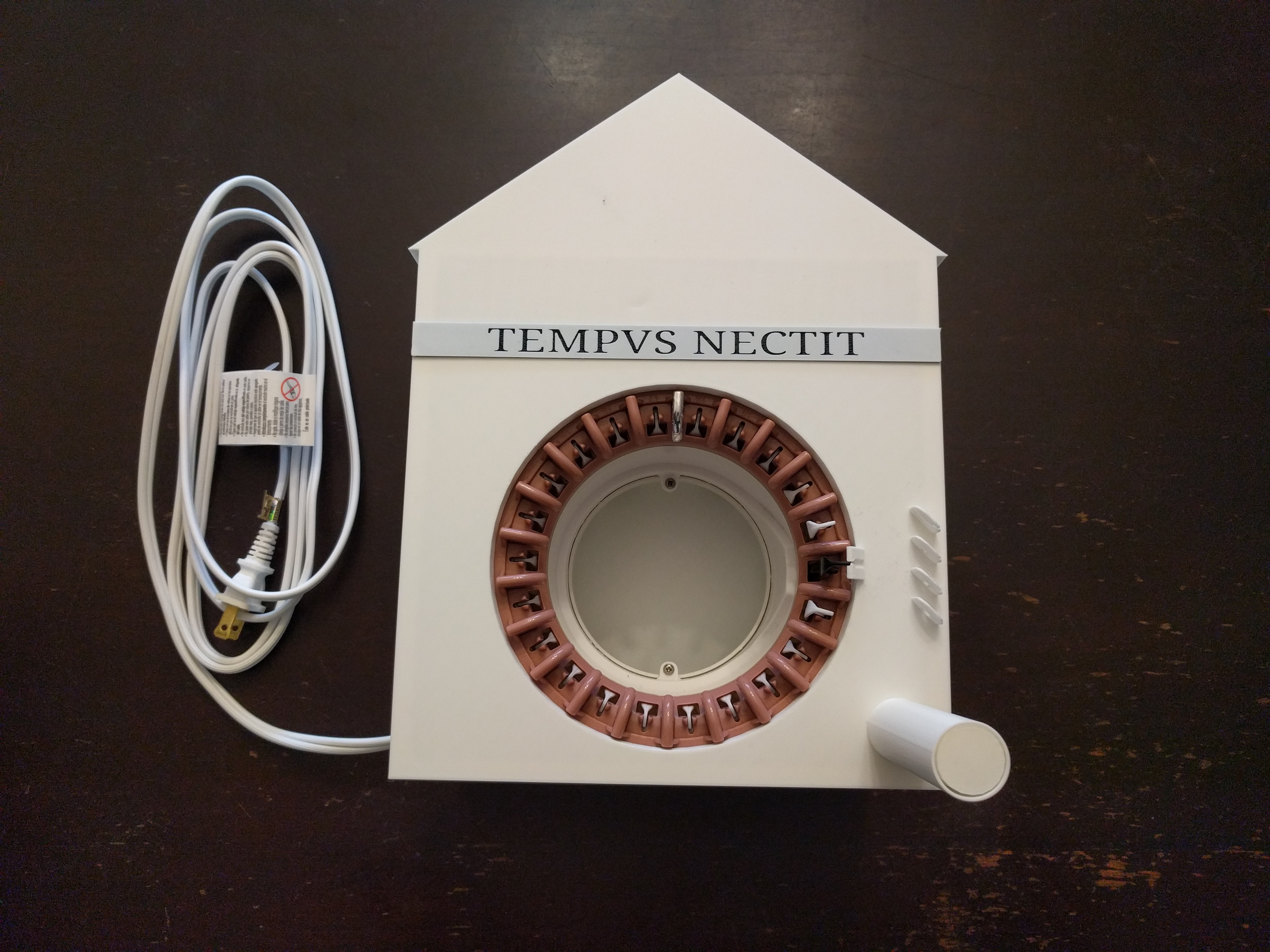 A white, house-shaped clock with the words 