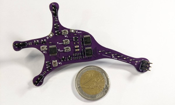 An electronic neuron implemented on a purple neuron-shaped PCB