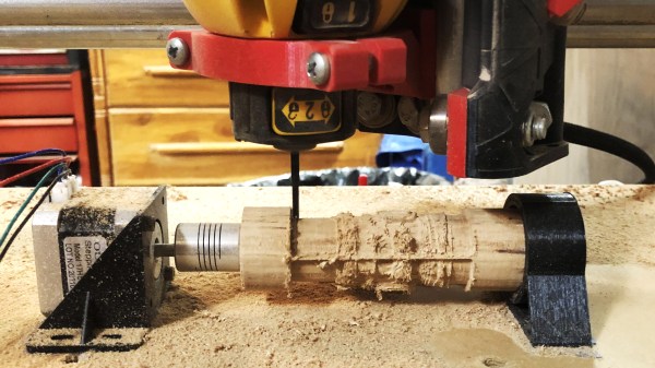 Wood game piece being carved by a CNC mill with a hacked rotary axis
