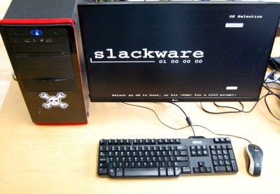 A desktop mini tower PC with monitor showing the Slackware boot screen