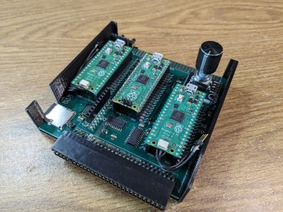 A 3D-printed box with a PCB inside holding three Raspberry Pi Picos and an SD card