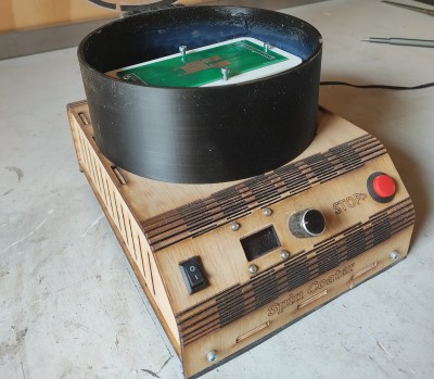 A wooden spin coating machine sitting on a desk