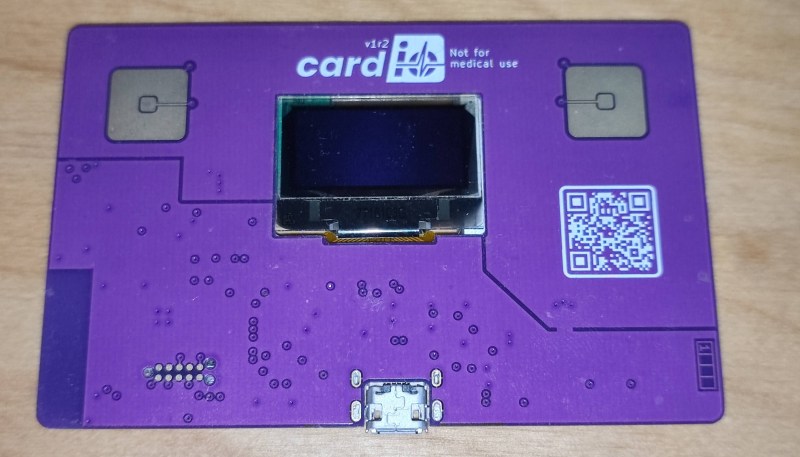 A credit card-sized PCB with two sensing pads and a small OLED display