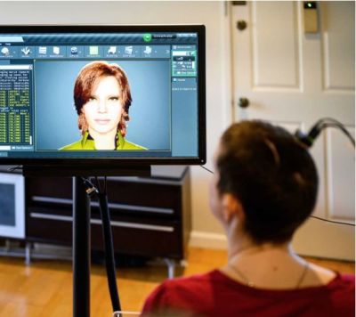 Ann looking at the avatar which speaks the phrases that were recorded using the BCI. (Credit: Noah Berger, UCSF)