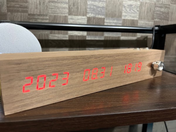 A wooden digital clock with a metal knob on one end