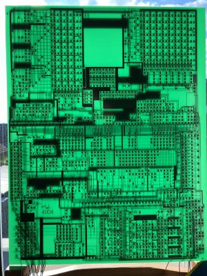 A PCB covered in discrete transistors with light shining through it