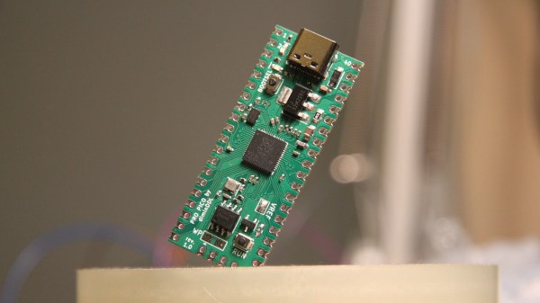 The Pi Pico replacement board in question, assembled, held diagonally in some type of holder