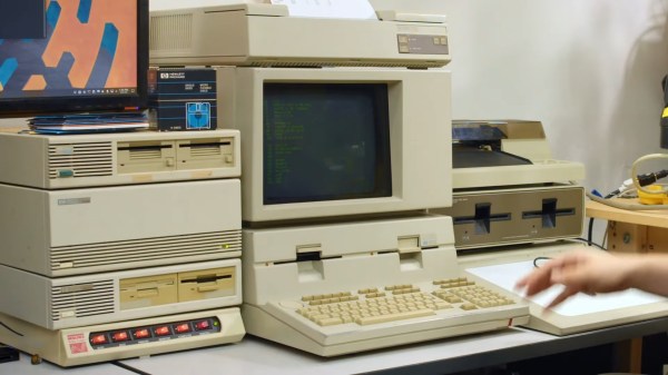 A beige computer with a CRT monitor. A black LCD sits atop a stack of 3 devices next to it and a set of power control switches (the orange light up kind). There appear to be 8 floppy drives available.