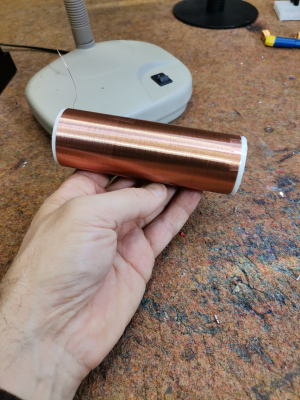 A hand holding a secondary coil for a Tesla coil build
