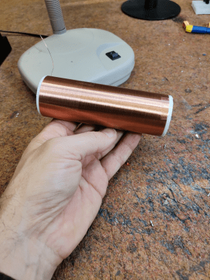 A hand holding a secondary coil for a Tesla coil build