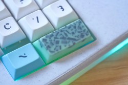 Way up close on the spacebar of a Le Chiffre 3D-printed small keyboard with mint chocolate chip space bars and a Ring Pop knob.