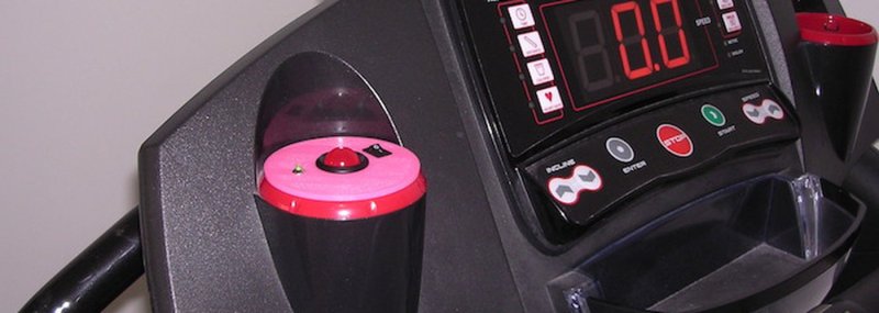 A treadmill with a doorbell alert in one of the cup holders.