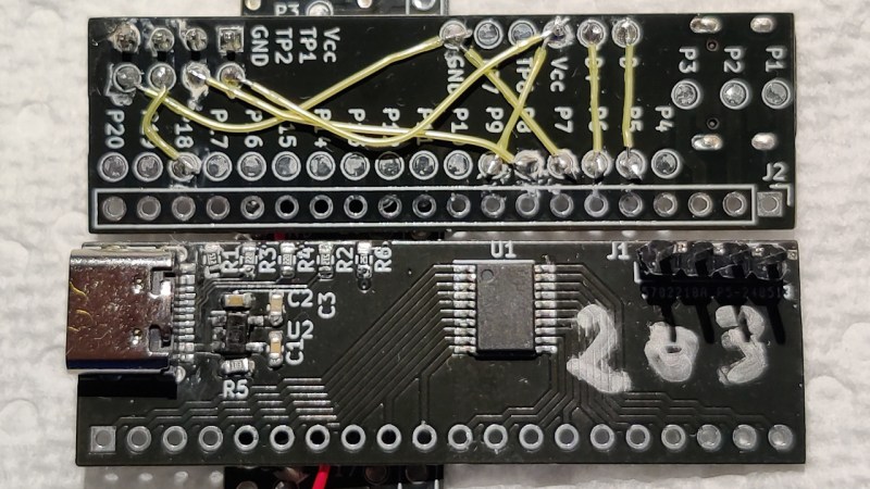 Two of these boards next to each other, one showing the front, assembled, side with the MCU and supporting components soldered on, and the other showing the back, patch panel, side, with wires connecting the MCU pads to testpoints leading to the supporting components