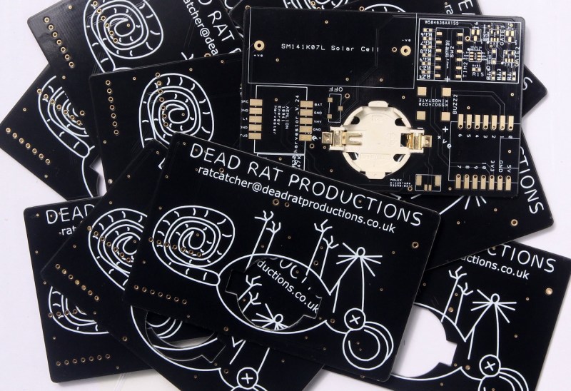 A bunch of unpopulated PCB business cards with rad dead rat artwork.