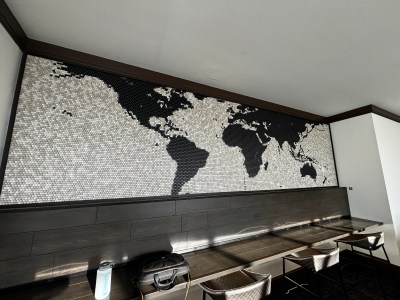 A world map on a wall made entirely from black, white, and grey keycaps.