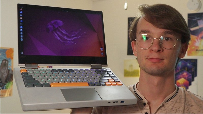 A Lenovo Yoga with a mechanical keyboard, held up by its creator.