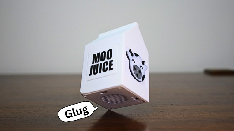 A 3D-printed talking milk jug with a speech bubble that says 'glug'.