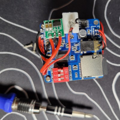 The innards of the milk jug. A sound module with SD card, a tilt switch, a boost converter, and so on. 