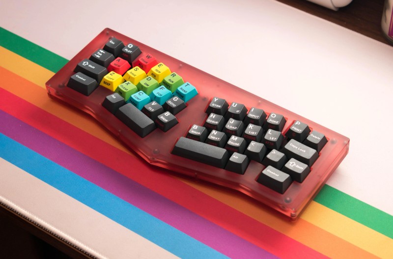 A Locus keyboard with Sinclair-inspired keycaps and a rainbow desk mat.