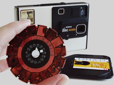 A Disc camera and Kodak film cartridge, with a developed negative being held in the foreground.