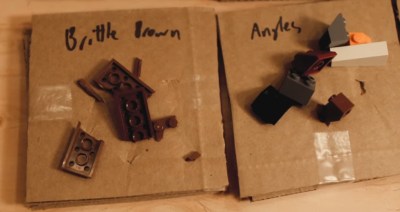 The damage done to cardboard by both broken brittle brown LEGO, and angled LEGO.