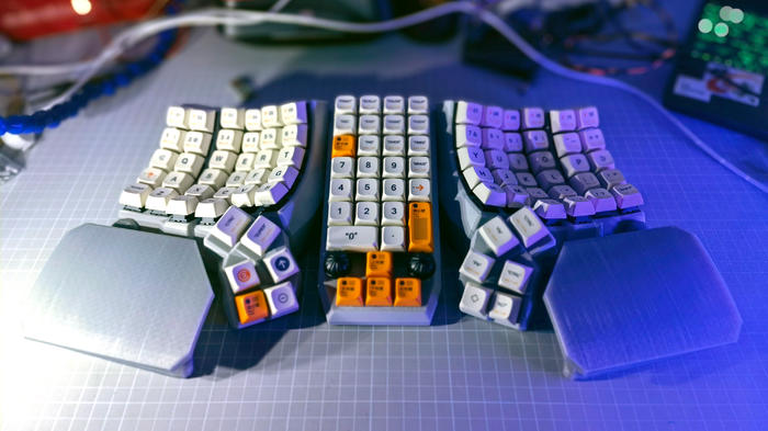 A 6x6 Dactyl Manuform keyboard with four columns of keys on a pad in between the halves.