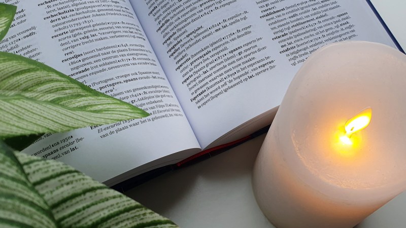 Close up of a Dutch etymology dictionary showing Esperanto, and a candle