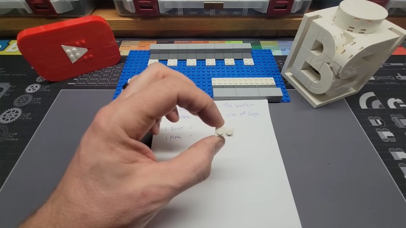 desk with a hand holding a Lego unit