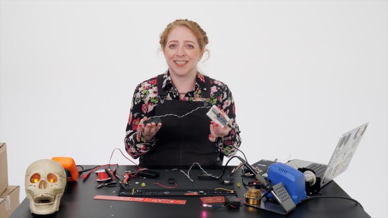 Wearables queen [Becky Stern] with a microcontroller and a speaker. And a skull!