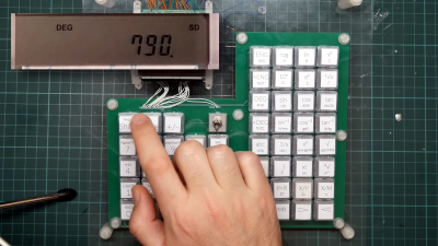 A finger hovers over a switch of an upgraded Casio calculator keyboard.