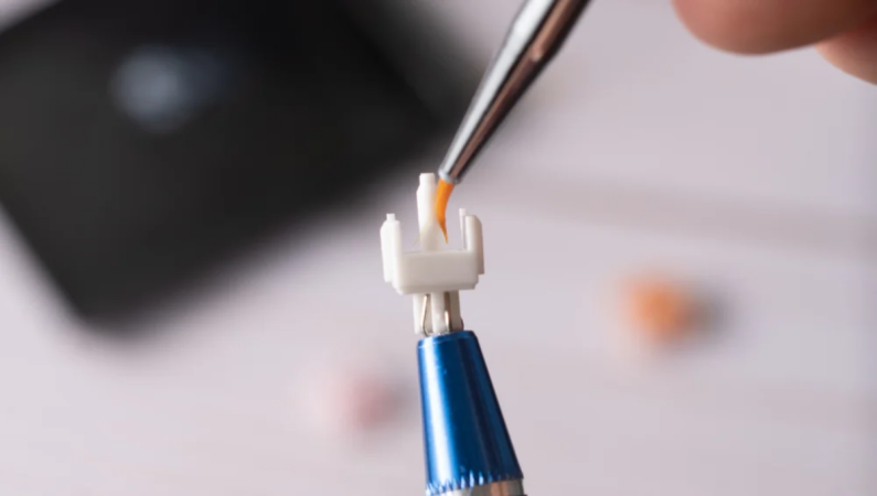 Lubricating a keyboard switch the proper way, with a brush and the switch opened up.