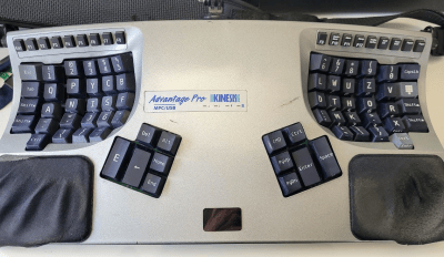 A silver Kinesis Advantage Pro with 3D-printed keycaps in the Maltron layout.